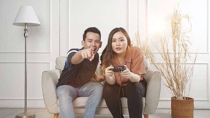 Woman playing video game and person pointing