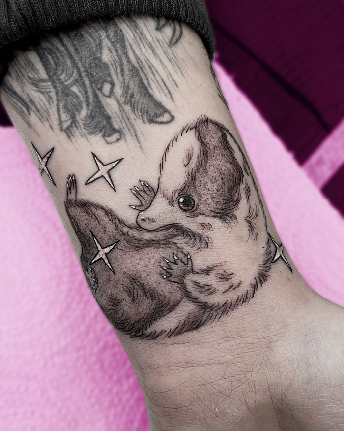 Harry Potter tattoo featuring a detailed badger with stars, symbolizing Hufflepuff loyalty.