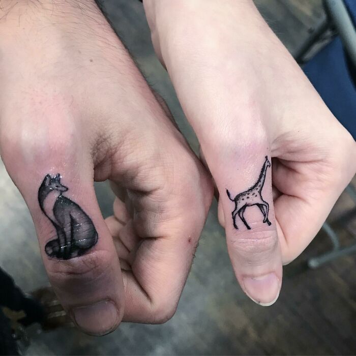 Fox and giraffe thumb tattoos