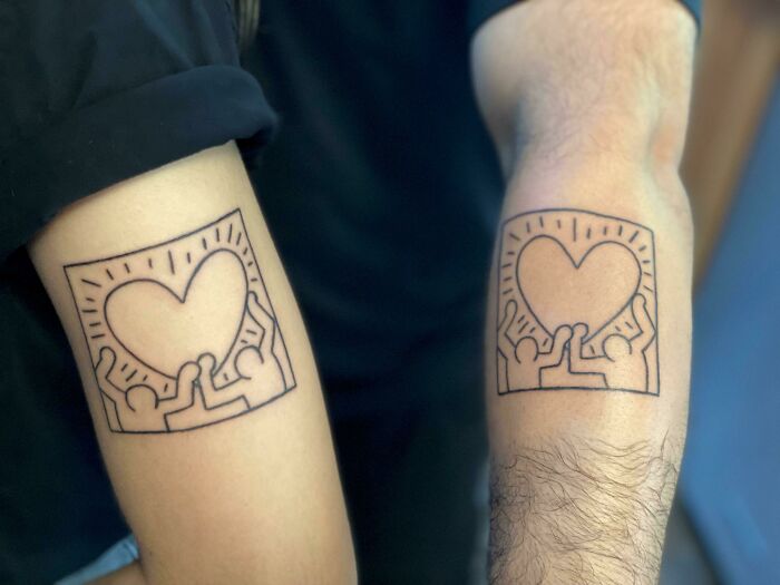 People holding heart matching tattoos