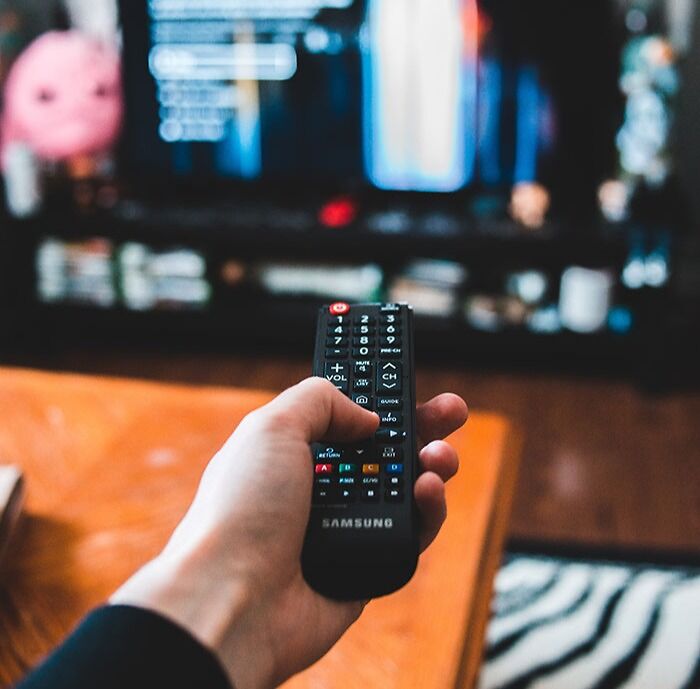 Person holding TV remote