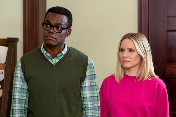 Chidi wearing glasses, Eleanor wearing pink sweater 