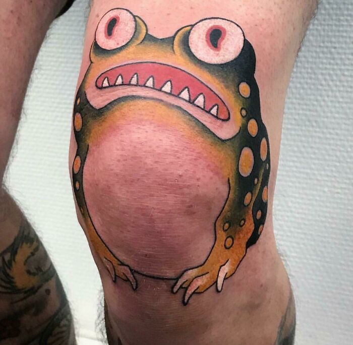 Un tatuaje de sapo en la rodilla