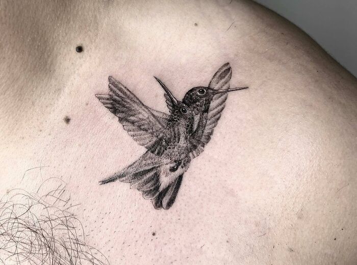Trippy blurred bird chest tattoo