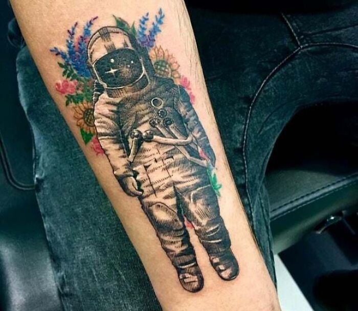 Astronaut with flowers arm tattoo