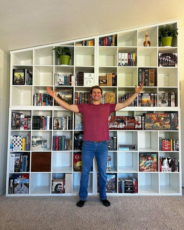Man standing in front of white bookshelves 