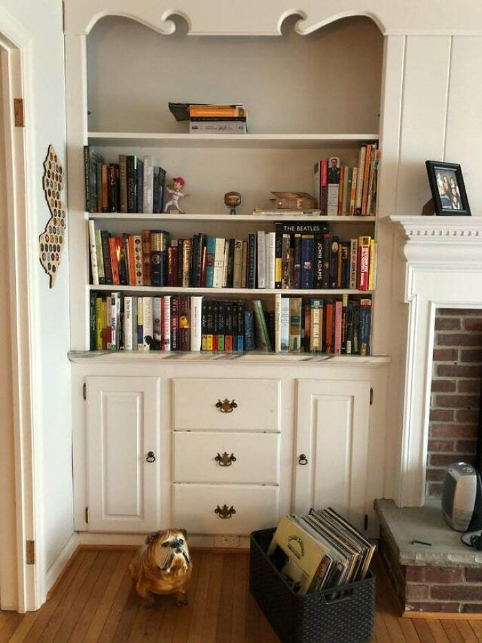 White bookshelf next to a fireplace 
