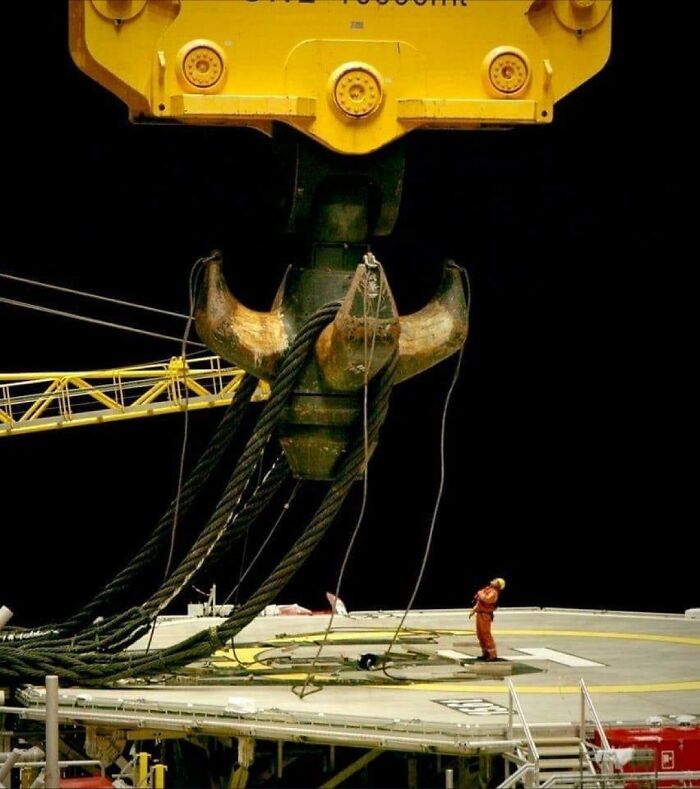 Crane Hook Next To A Worker On An Offshore Drilling Rig