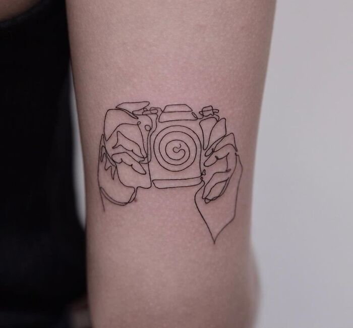 Single line photo camera with hands tattoo