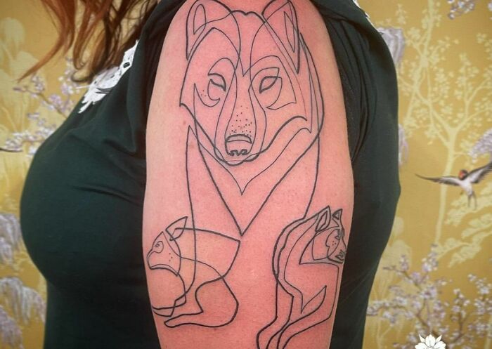 Three wolfes tricep tattoo