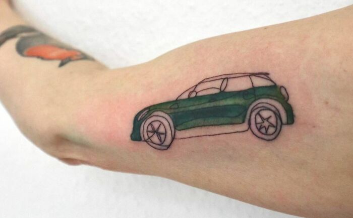 Single line green ink car tricep tattoo