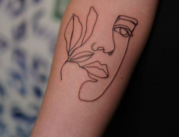 Single line abstract face with flower tattoo
