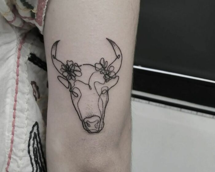 Single line animal head with horns and flowers elbow tattoo