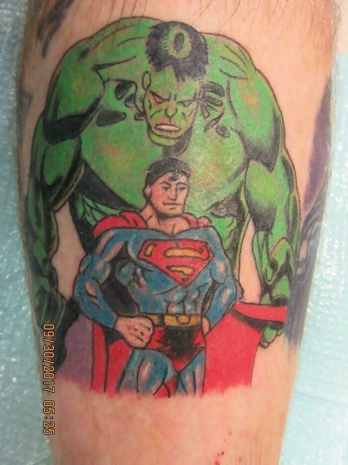 Funny tattoo of Hulk with a small Superman on an arm.