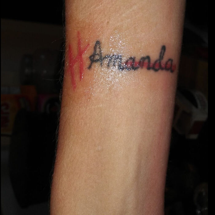 Funny word hand tattoo with the name Amanda humorously misspelled in red.