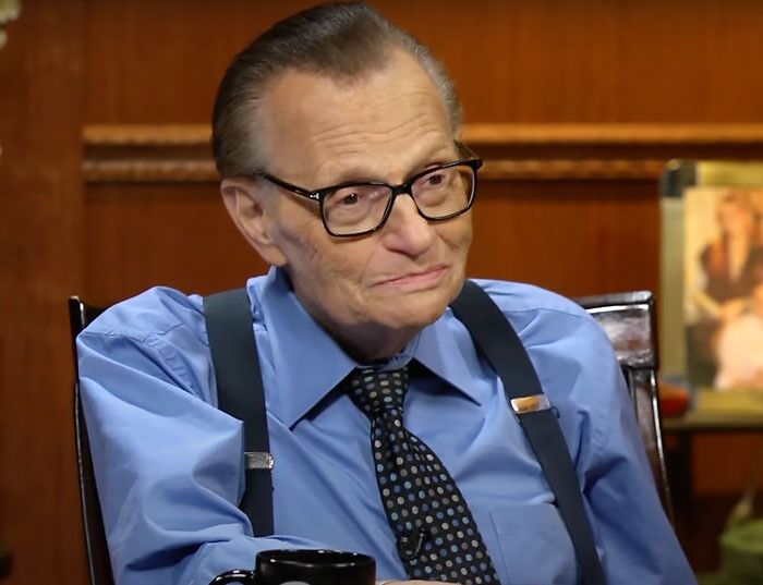 Larry King wearing blue shirt and a tie 