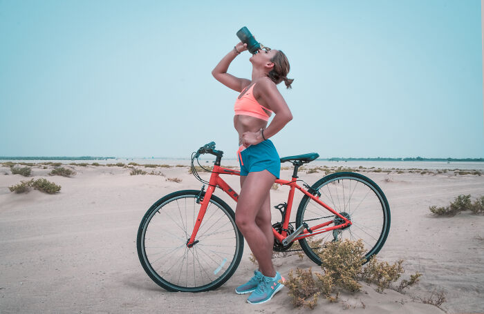 Woman drinking water while on the bike 
