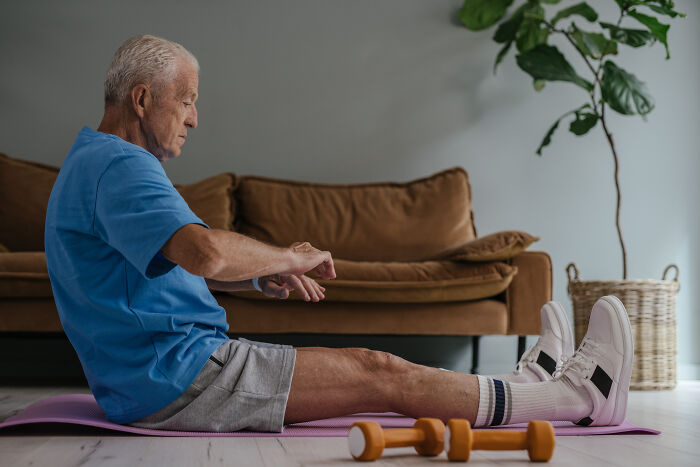 Old man doing exercise on a yoga mat 