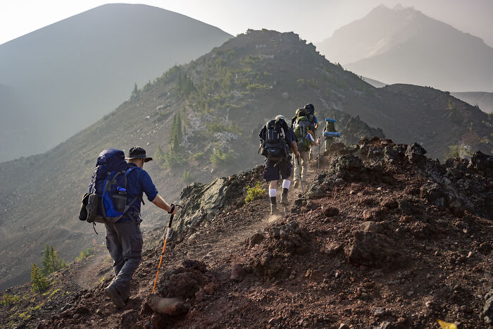 A group of people hiking on top of a mountain 