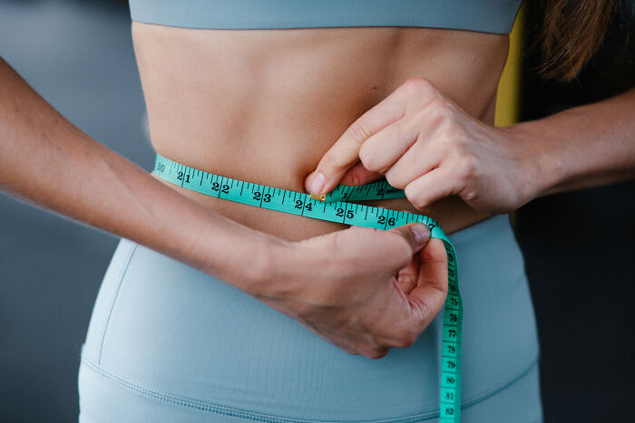Woman measuring her waist 