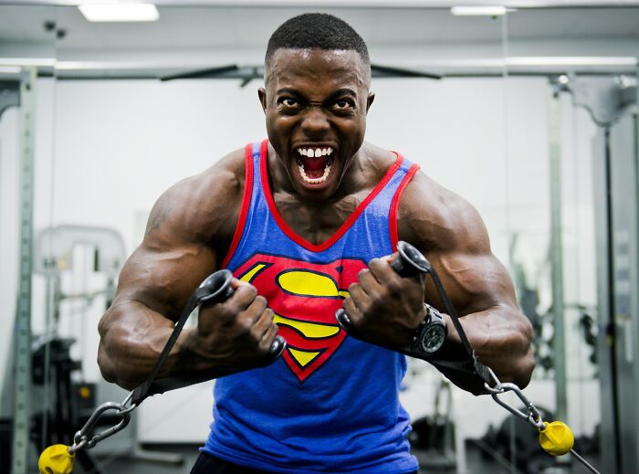 Man in a Superman shirt using gym equipment 