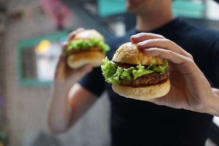 Man holding two burgers in is hands 