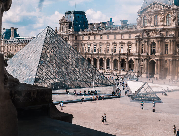 The Louvre Museum with many people walking near by 