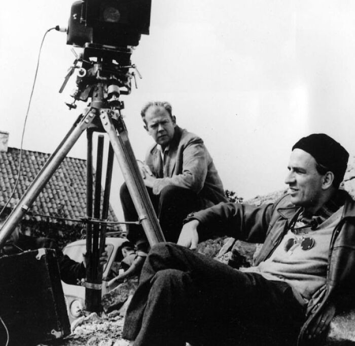 Ingmar Bergman sitting on the ground behind the camera 