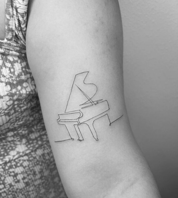 Single line piano arm tattoo