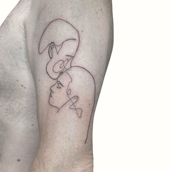 Single line woman and man face kiss arm tattoo