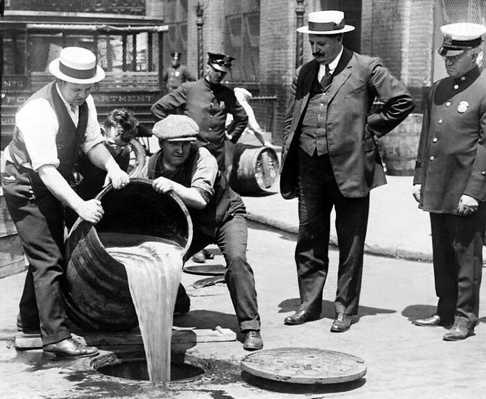 New York City Deputy Police Commissioner John A. Leach, Right, Watching Agents Pour Liquor Down A Manhole Following A Raid During Prohibition 1921