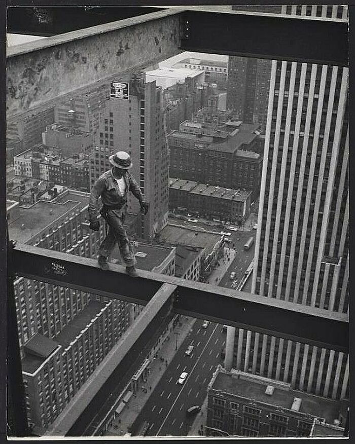 Un obrero de la construcción de Nueva York camina por una viga a gran altura sobre las calles de la ciudad, alrededor de 1950