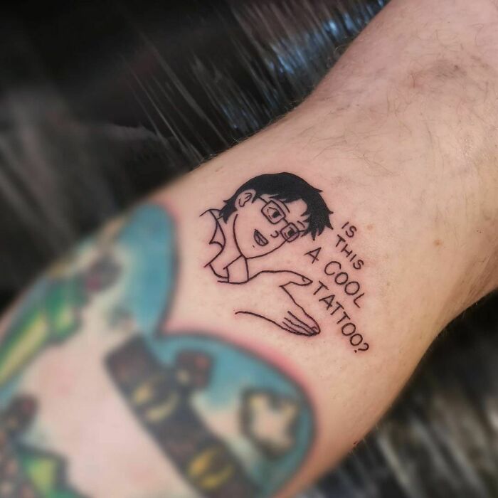 Funny tattoo of a cartoon character with the text "Is this a cool tattoo?"