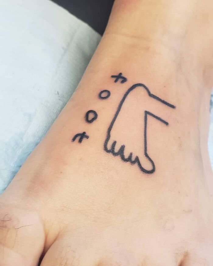 Funny tattoo of a foot with squiggly toes and whimsical text, creating a humorous design.