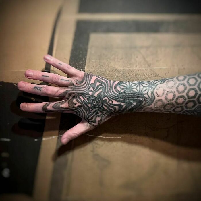 Arm with optical illusion tattoo, featuring intricate patterns and shapes playing tricks on your eyesight.