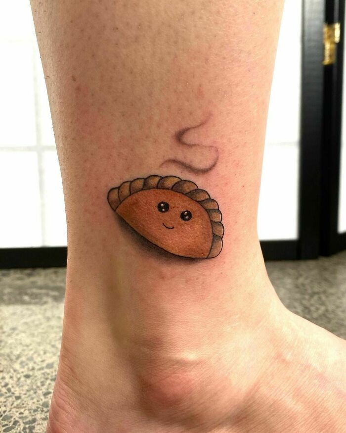 Cute pie tattoo with a smiley face on leg, showcasing funny tattoos.