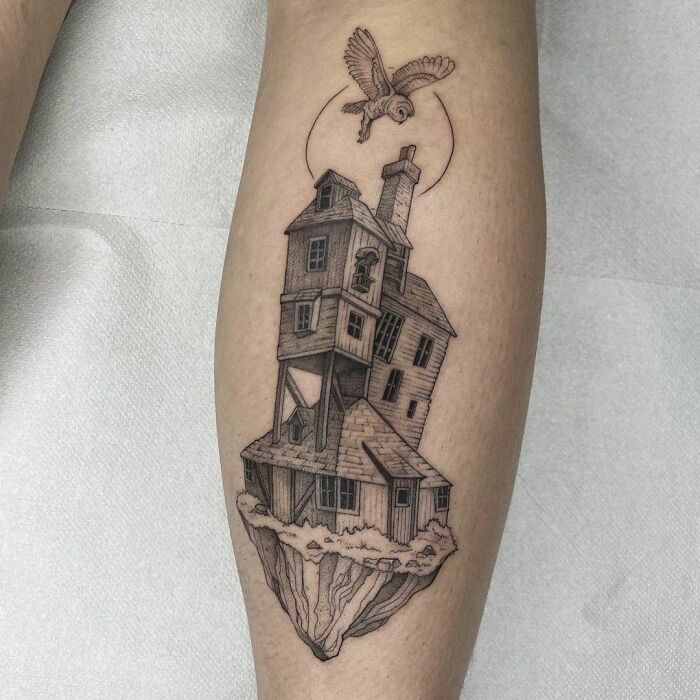 Harry Potter tattoo featuring a floating house and an owl on a person's leg.