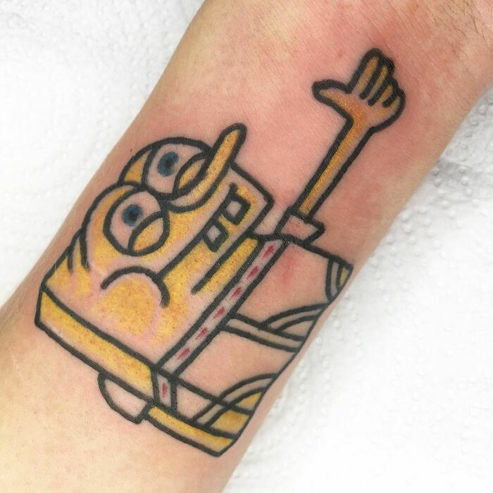 Funny SpongeBob hand tattoo on forearm, showcasing a playful design that highlights humor in body art.