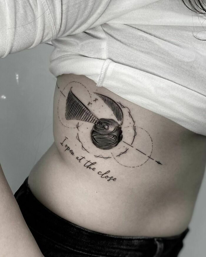 Harry Potter tattoo of a Golden Snitch with "I open at the close" text on a person's side.