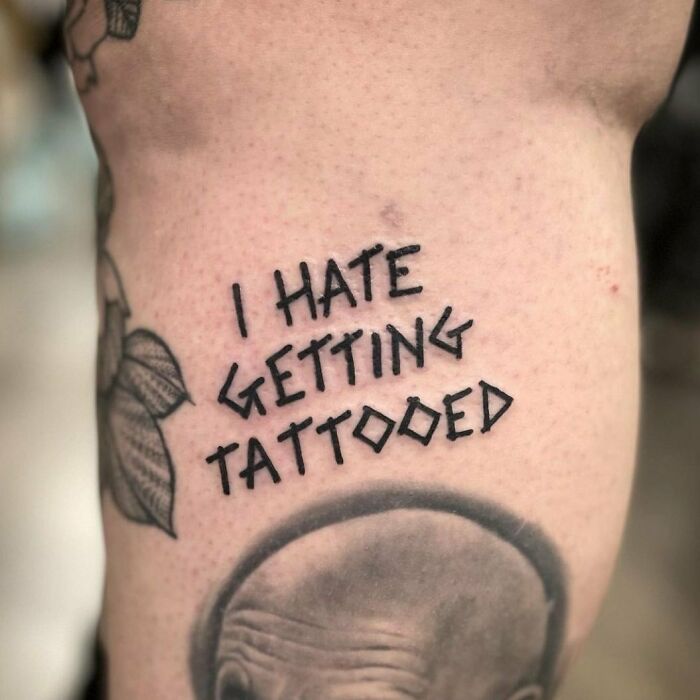 Funny tattoo with the words "I hate getting tattooed" on skin.