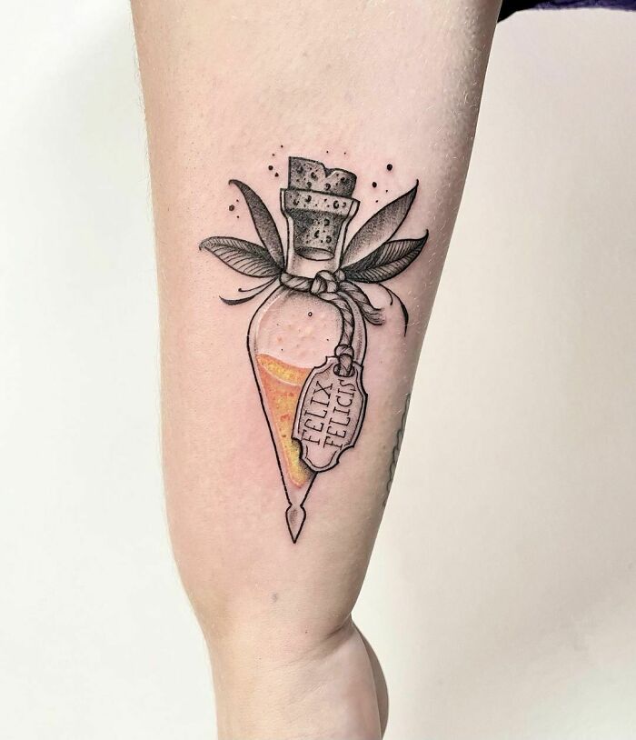 Felix Felicis potion tattoo on an arm, showcasing Harry Potter tattoo design for fans.