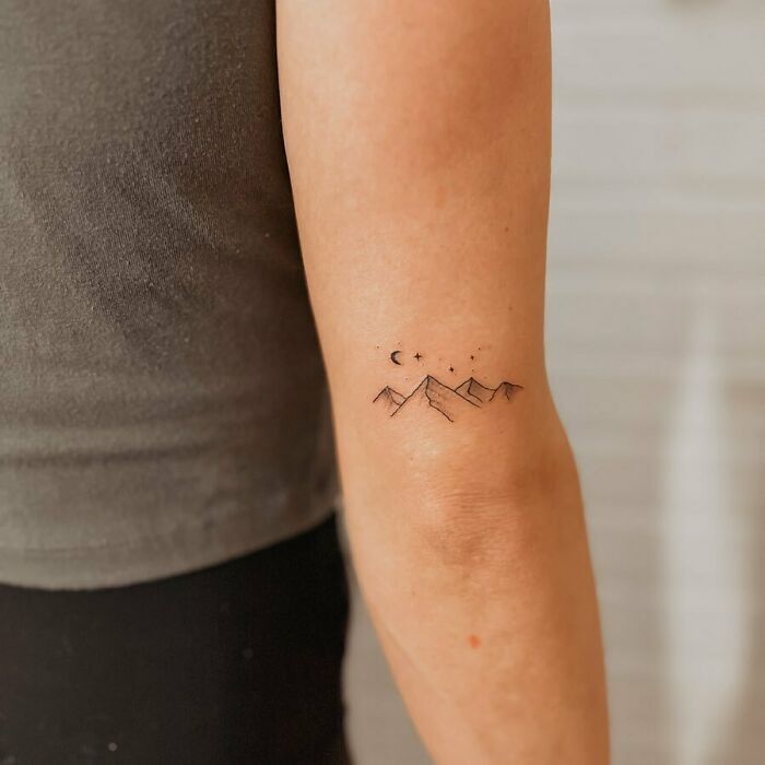 minimalistic tattoo of mountains and moon