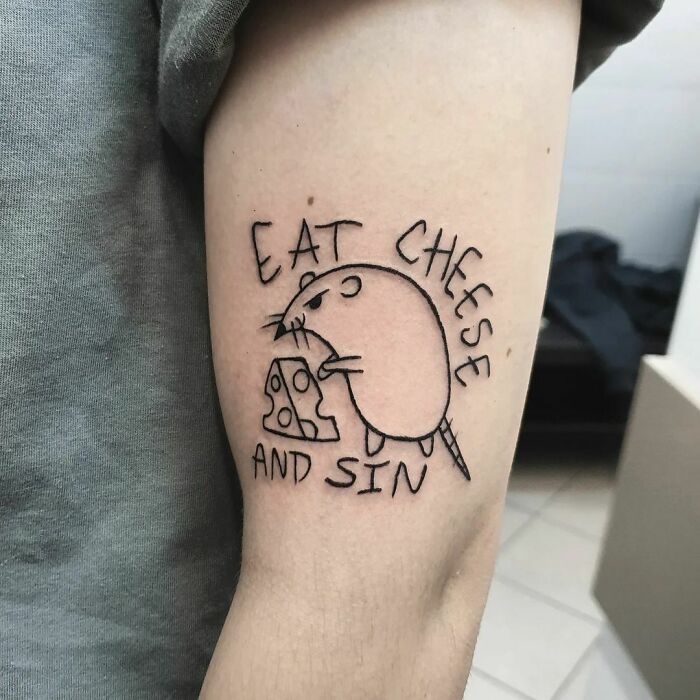 Funny tattoo of a cartoon rat holding cheese with the phrase "Eat Cheese and Sin" on an arm.