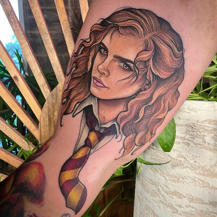 Detailed Harry Potter character tattoo featuring curly hair and school tie.