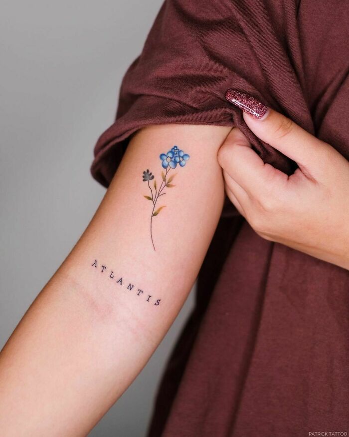 minimalistic tattoo of a flower and typography