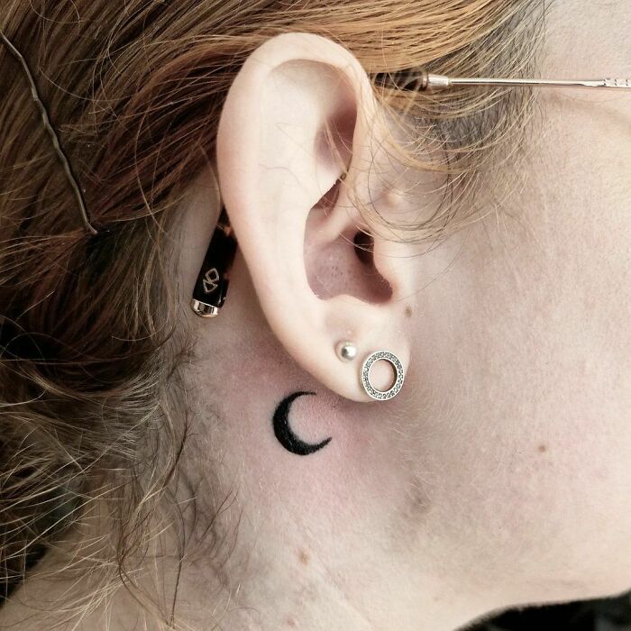 Minimalistic moon tattoo near the ear