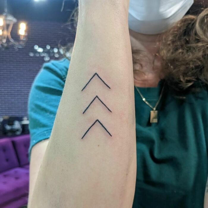 minimalistic tattoo of arrows pointing upwards