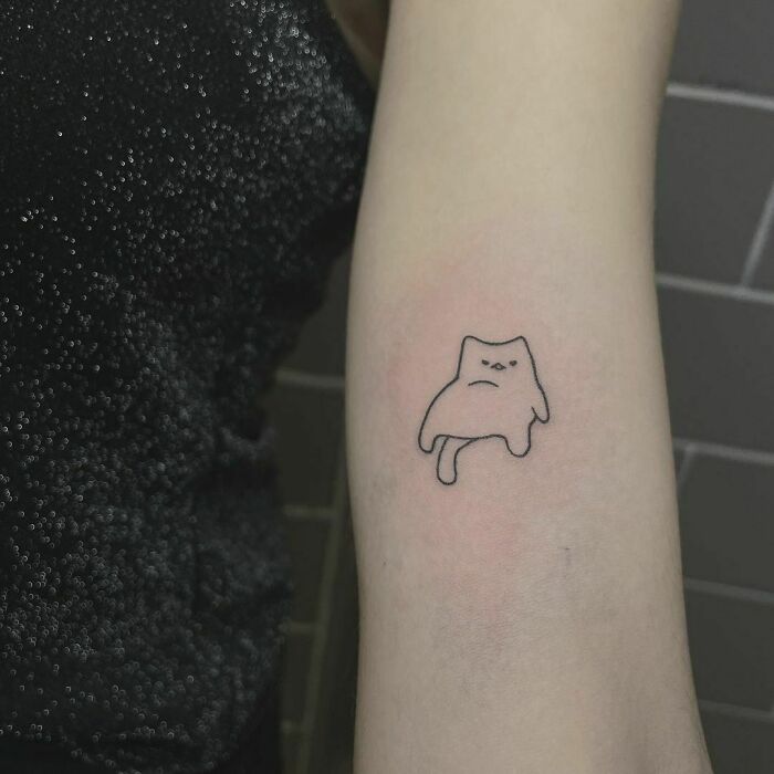 Funny and small lazy kitten arm tattoo 