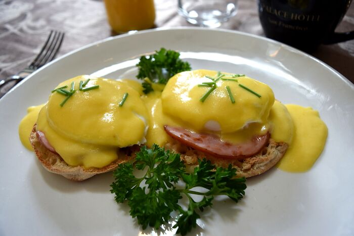 Two eggs benedict on a white plate 