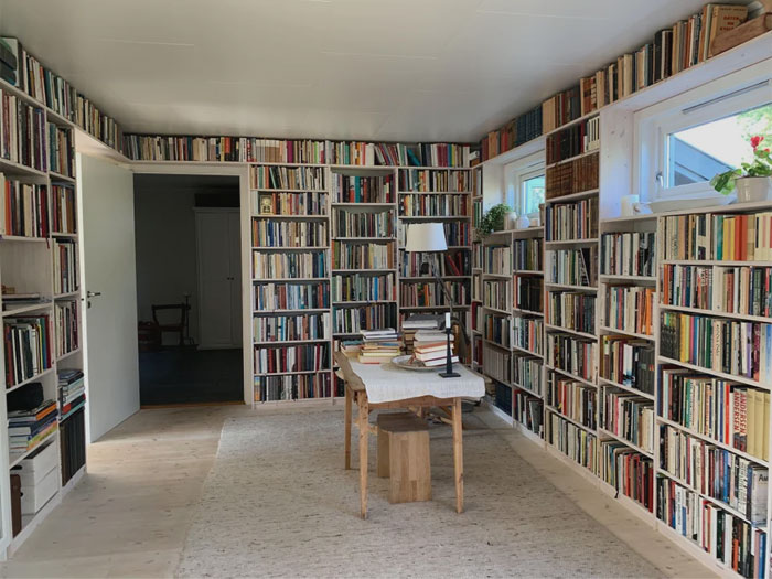 A room with bookshelf on the walls 